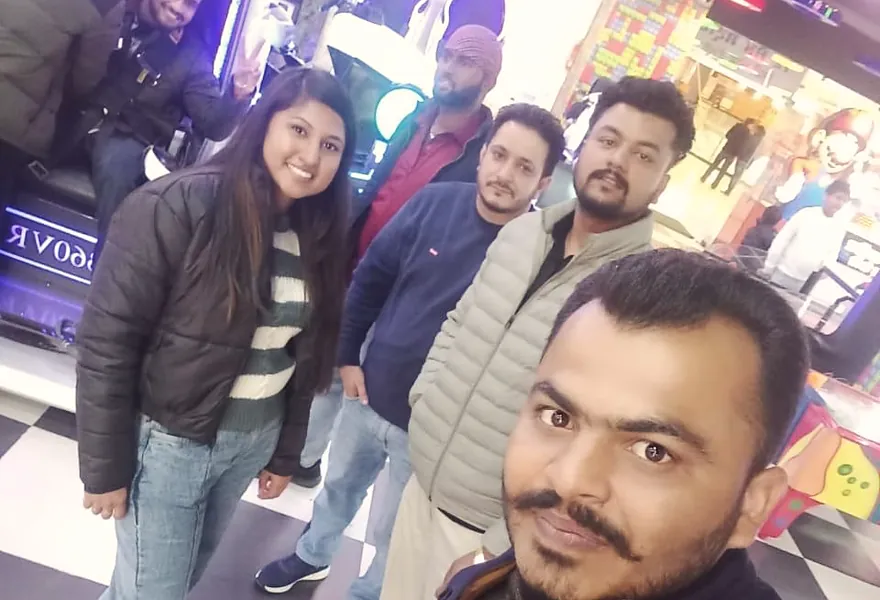Four colleagues outside a shop at night