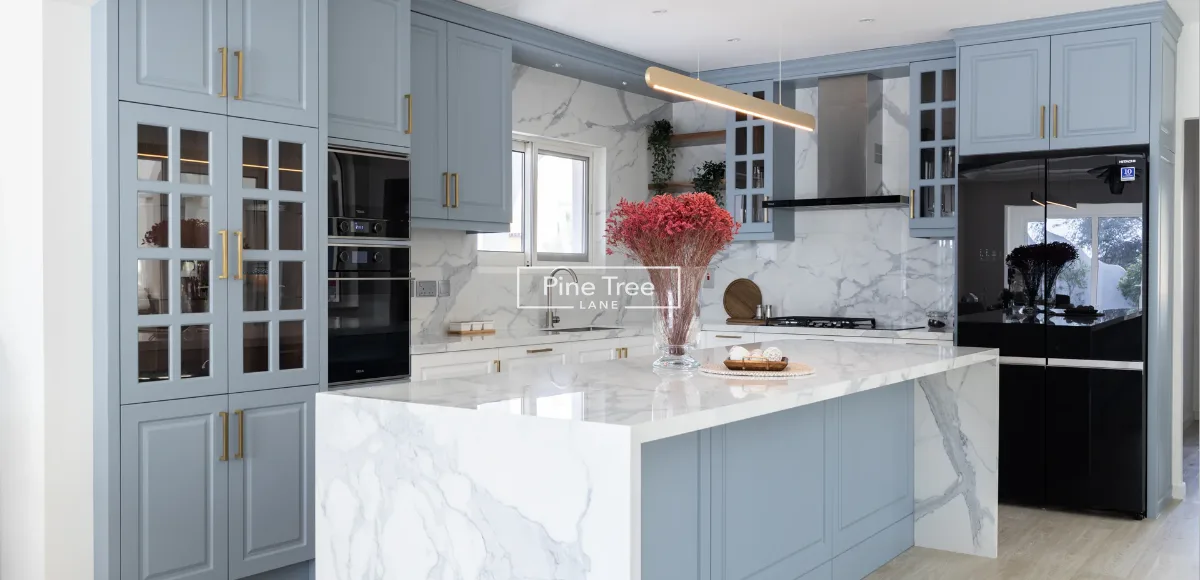 Pine Tree Lane kitchen: pale blue cabinetry and a marble island in a Dubai villa